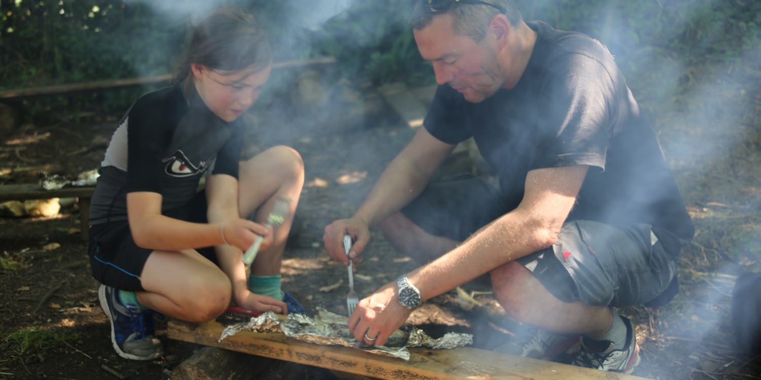 Father and daughter cooking outdoors