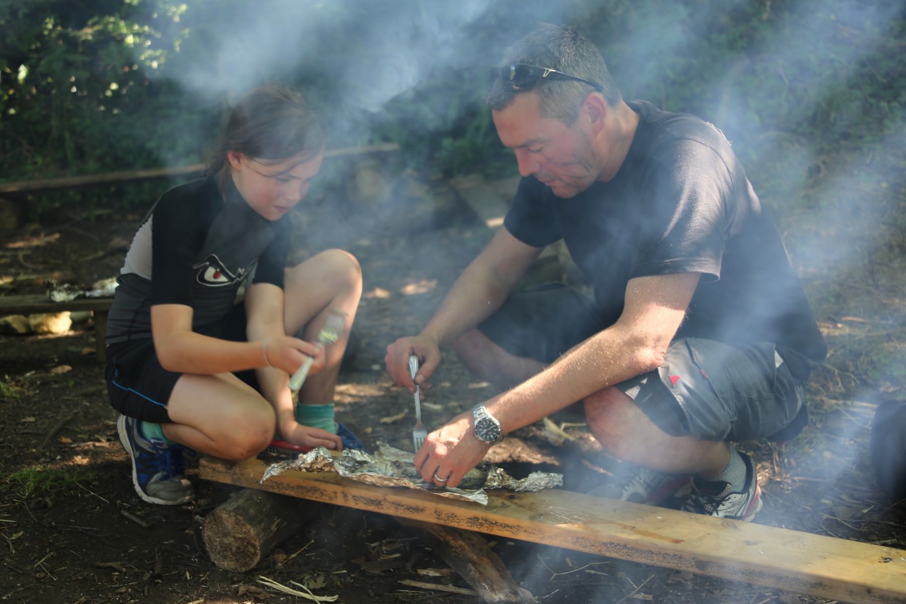 Father and daughter cooking outdoors
